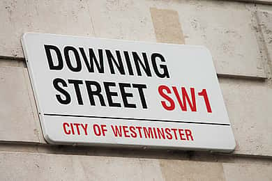 Downing Street road sign highlighting the impact of political changes on business sustainability strategies.